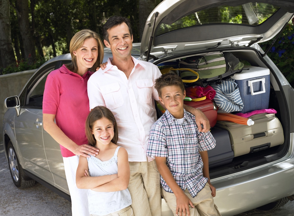 Family in front of packed car for vacation