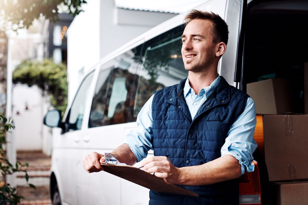 Man with clipboard in front of commercial van
