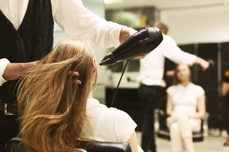 Stylist drying hair in salon