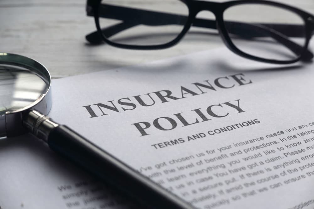 Insurance policy letter, with magnifying glass and eyeglasses