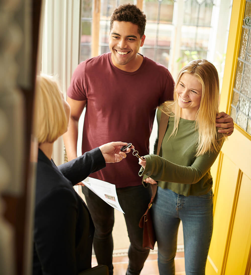 Landlord handing keys to couple.