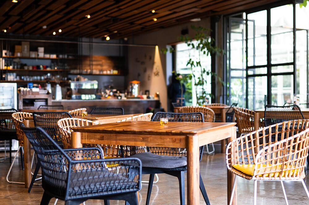 Restaurant tables in front of large windows.