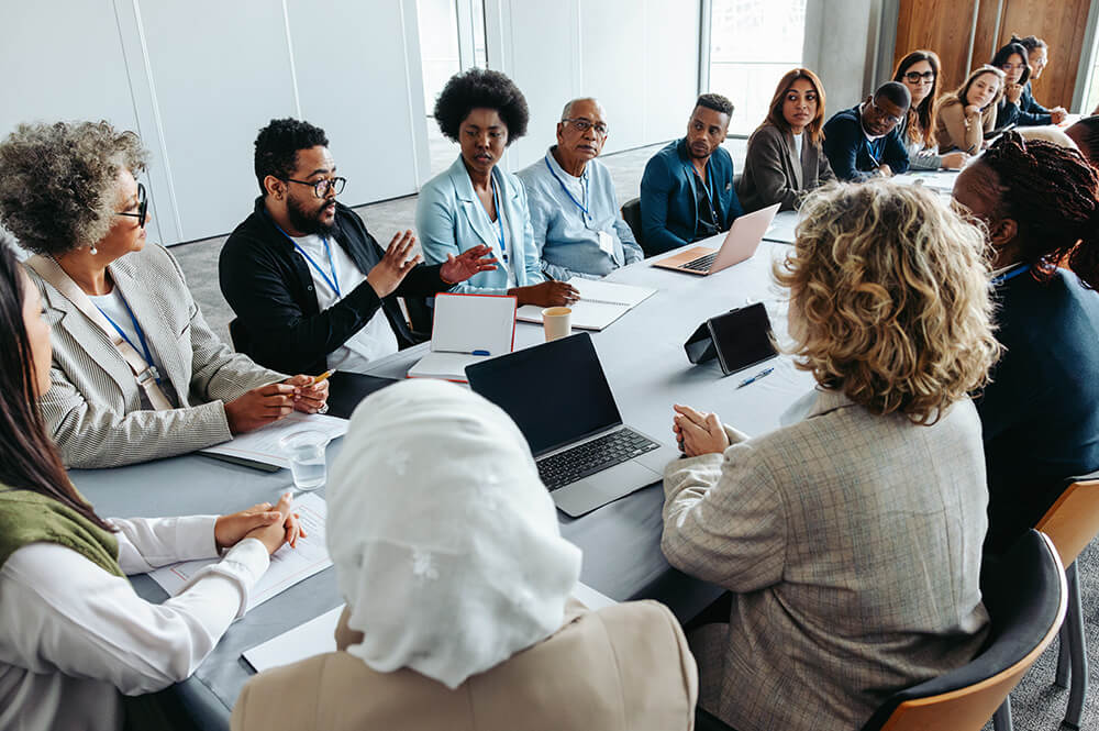 Condo association meeting in room with table of adults discussing a topic.