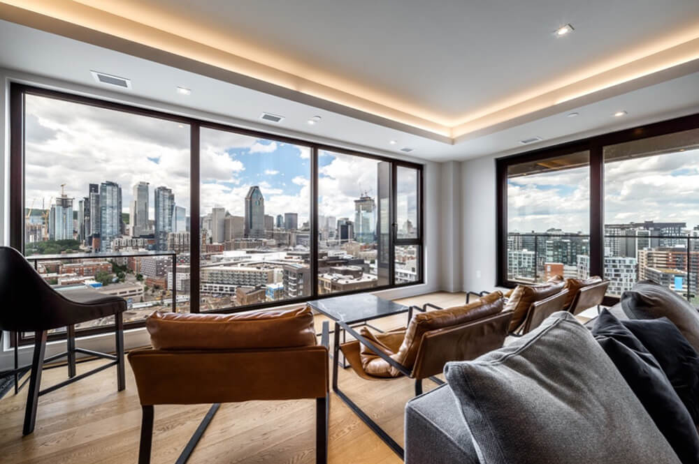 Jersey City condo living room with large glass windows looking out over the city.
