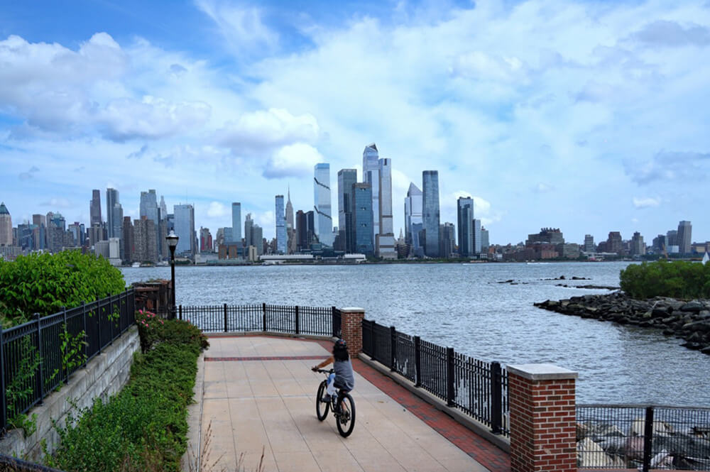 Cyclist on the Weehawken NJ waterfront promenade along the Hudson River